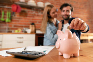 Couple putting money in piggy bank