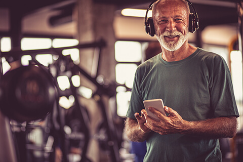 Older man in gym with phone