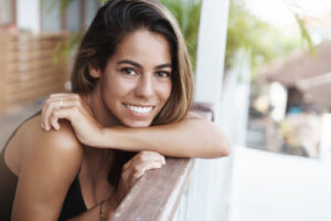 woman smiling while on outdoor patio